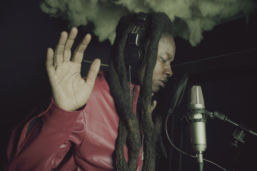 Artist recording in studio with microphone and headphones